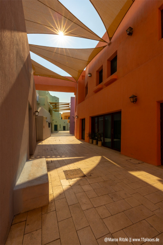 Enge Gasse im Mina District Doha mit Sonnenstern bei Tageslicht